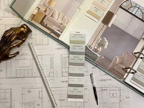 Working desk with blueprints, ruler, and a pen